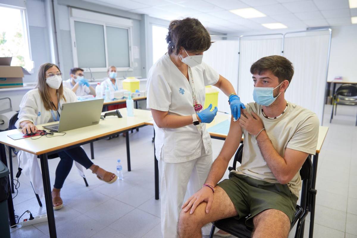 Un joven se vacuna en el centro de vacunación sin cita previa que se ha montado en la Universidad de Girona (Foto: EFE/David Borrat)